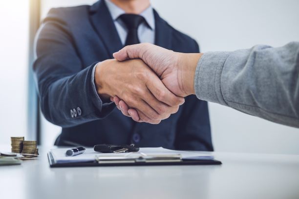 Borrower and lender shake hands after finalising a car loan