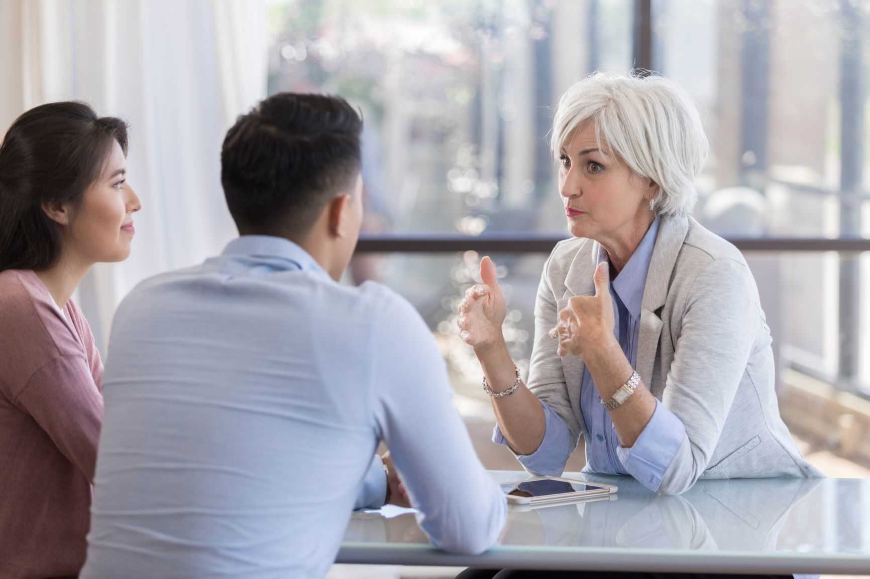 A young couple talking to a Mortgage Adviser to know more about home loans