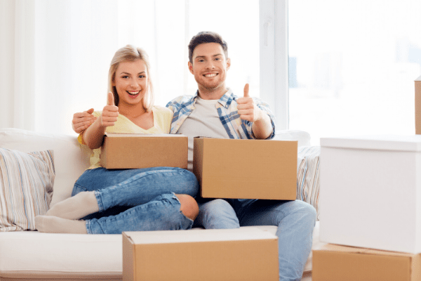 Happy couple with boxes moving to new home