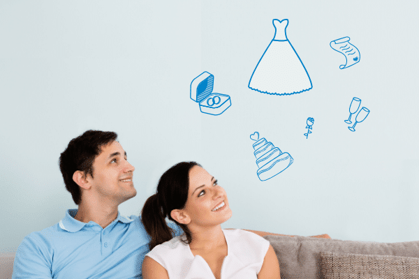 Young couple sitting on a couch and planning their wedding