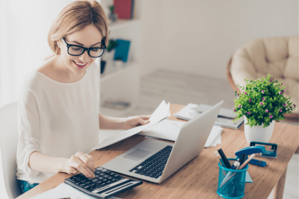 Home owner working with calculator and computer to check if refinancing makes financial sense