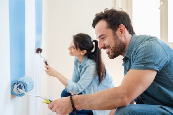 Young couple painting walls in their house