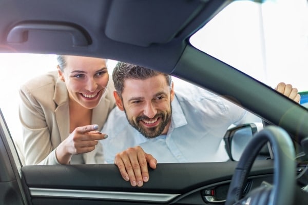 Young couple in the showroom choosing a car