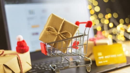 Trolley with Christmas gifts, bank card and laptop