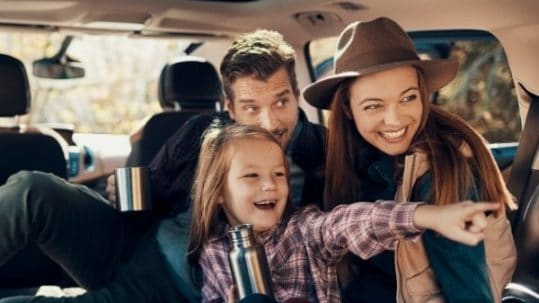 Excited family on a road trip in car