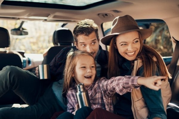 Excited family on a road trip in car