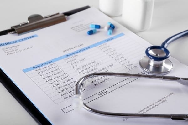 Medical bills with stethoscope on a desk