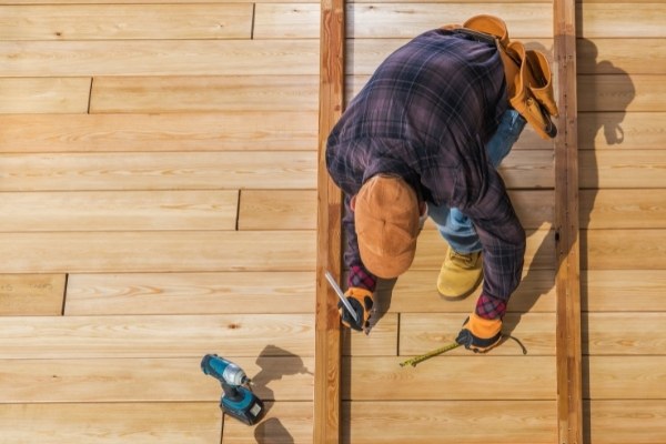 Man building wooden deck for his backyard garden