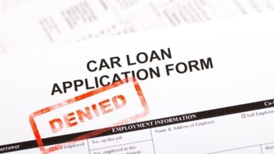 A car loan application form with a red “DENIED” stamp