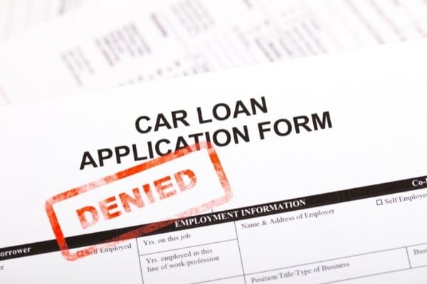 A car loan application form with a red “DENIED” stamp
