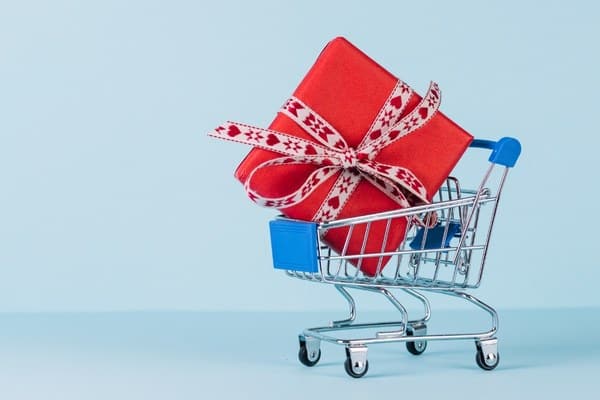 Wrapped Christmas gift box in blue shopping cart