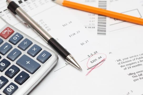 Unpaid bills on table with calculator and pen