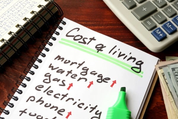 A notebook page with a list titled 'Cost of living'. List contains the cost of living components with red upward arrows next to each of the components.